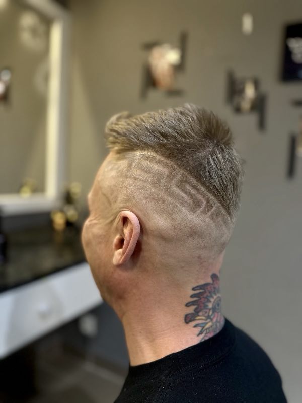 Men's fade with a geometric hair design carved into the side