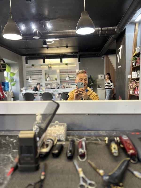 The barber station with tools laid out and the salon behind